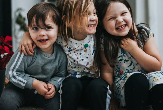 Three children smiling together