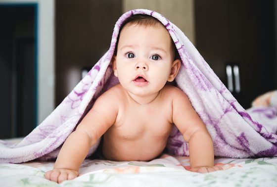 Baby with blanket draped over it
